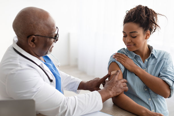 doctor applying bandaid to patient.